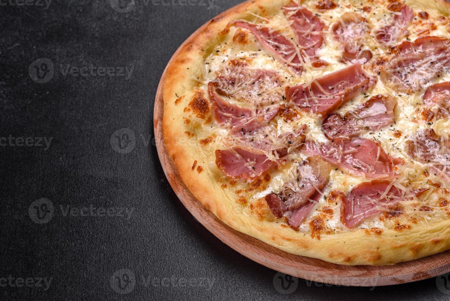 deliziosa pizza fresca e croccante dal forno con prosciutto, formaggio e basilico foto