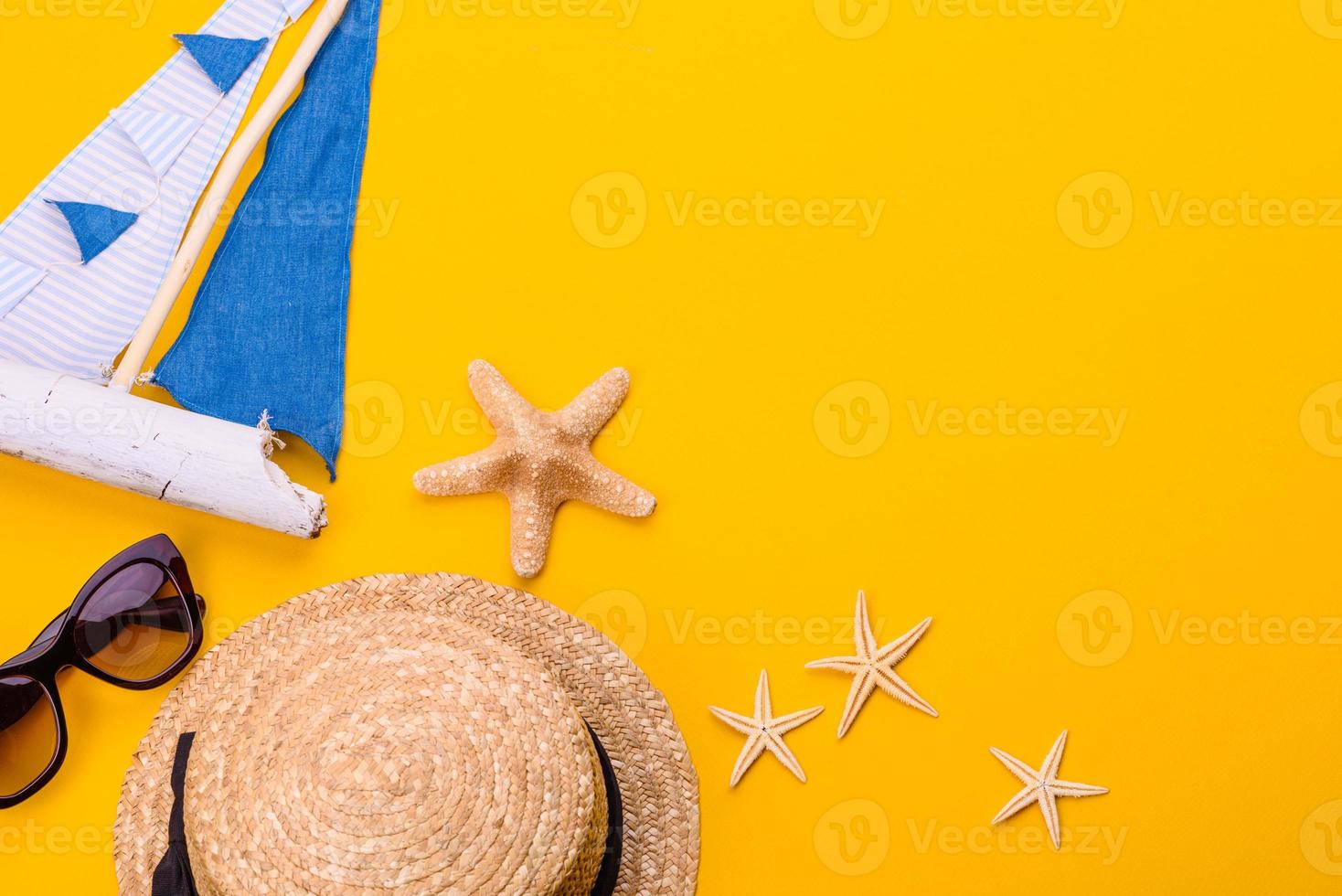 occhiali e cappello con conchiglie e stelle marine su sfondo colorato foto