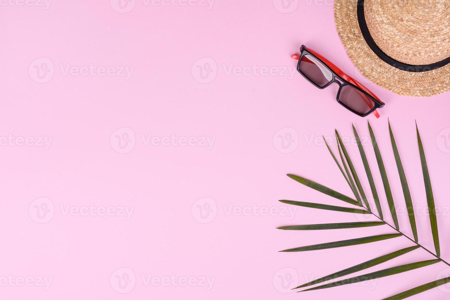 carambola di frutta, accessori da spiaggia e fogliame di una pianta tropicale su carta colorata foto