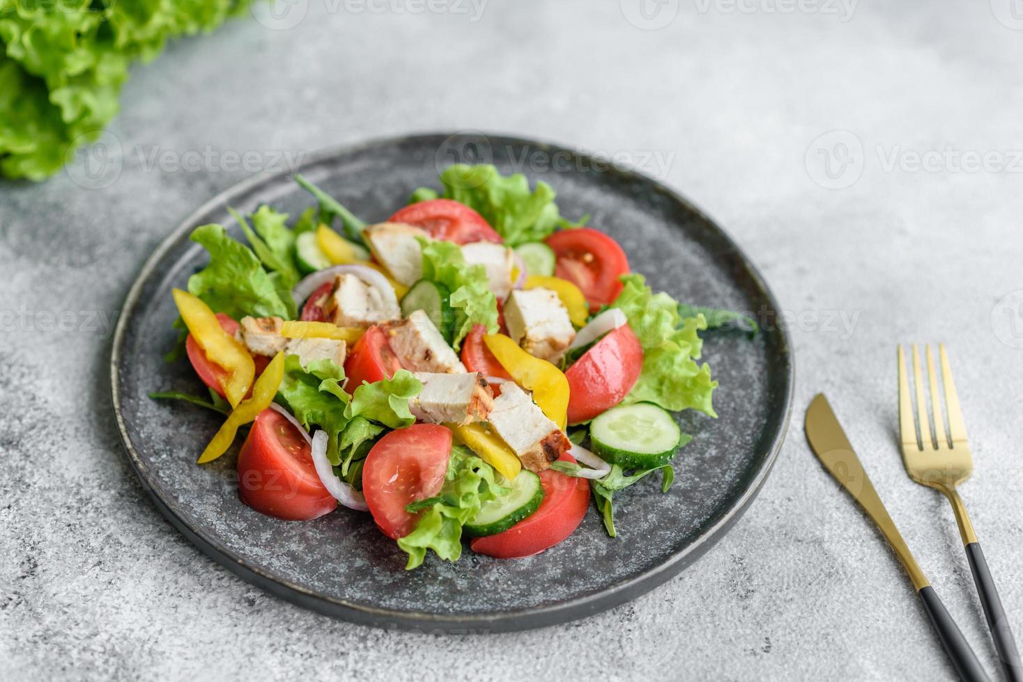 deliziosa insalata fresca con pollo, pomodoro, cetriolo, cipolle e verdure con olio d'oliva foto