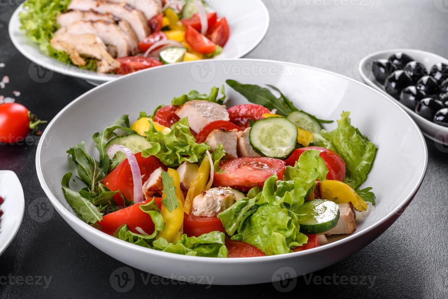 deliziosa insalata fresca con pollo, pomodoro, cetriolo, cipolle e verdure con olio d'oliva foto