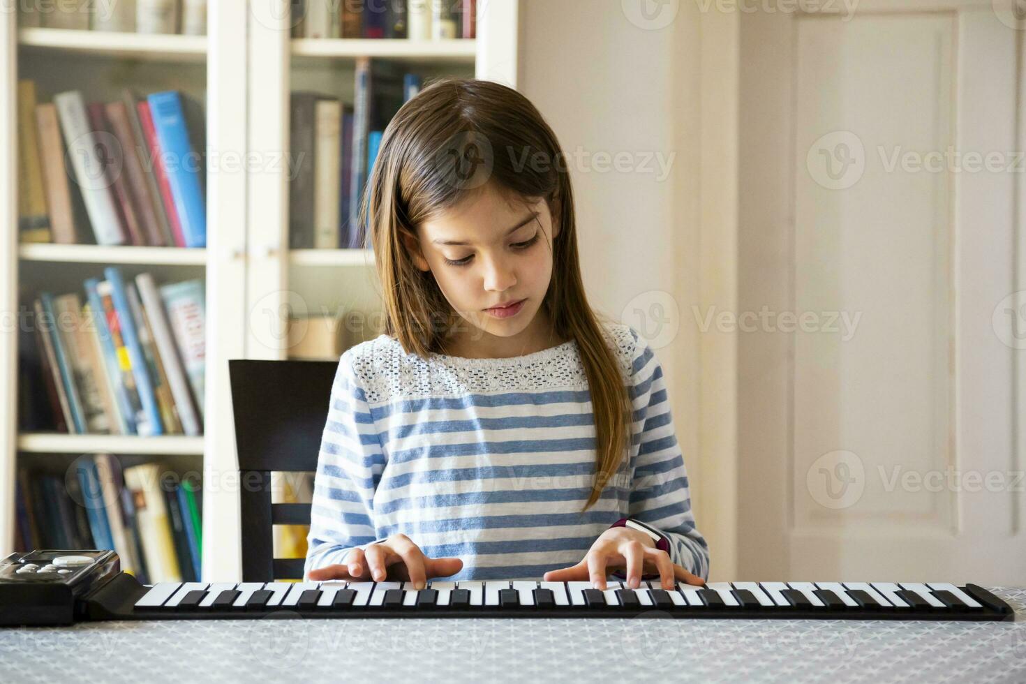 ragazza giocando rotolo pianoforte a casa foto