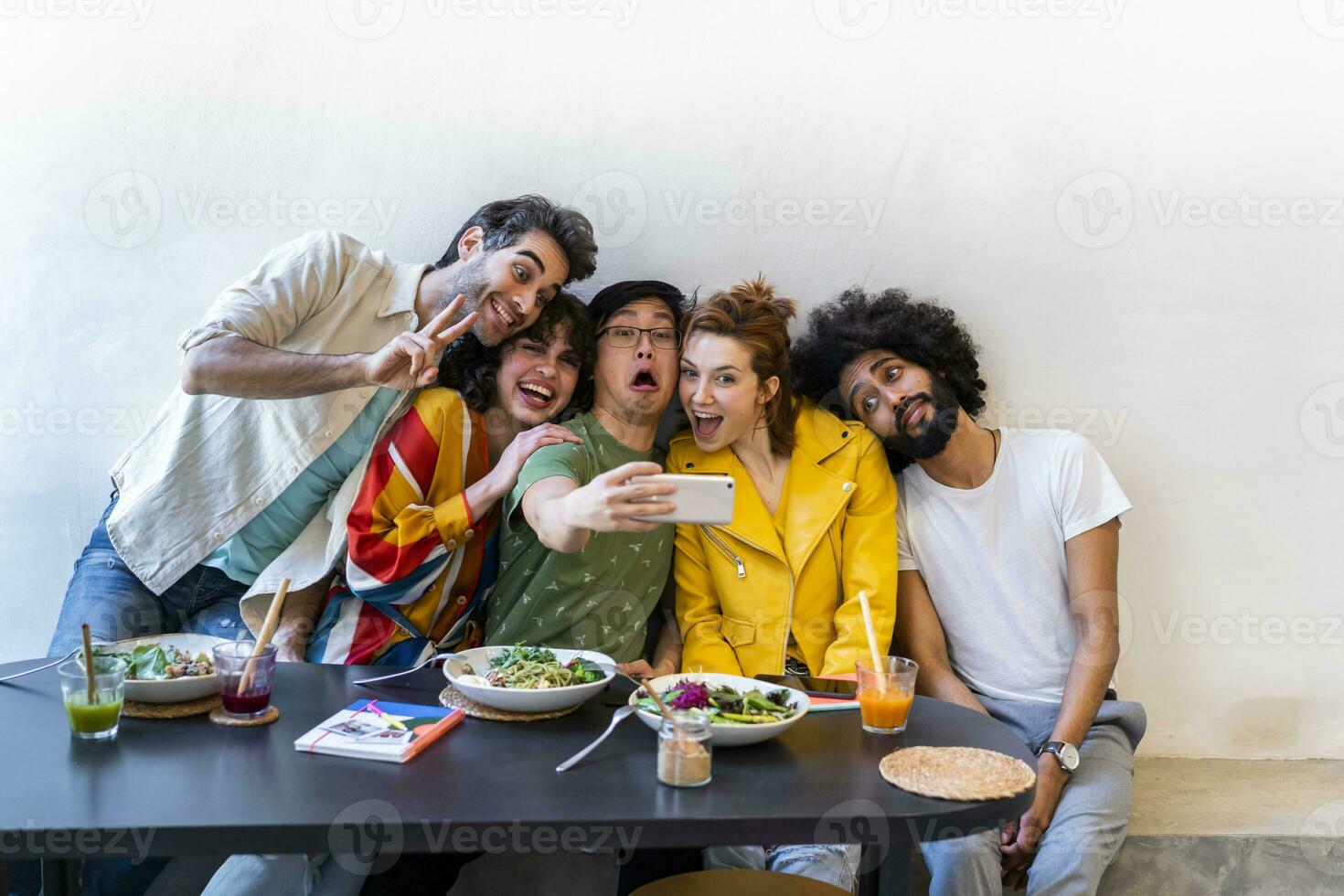 gruppo di amici avendo pranzo nel un' ristorante assunzione un' autoscatto foto