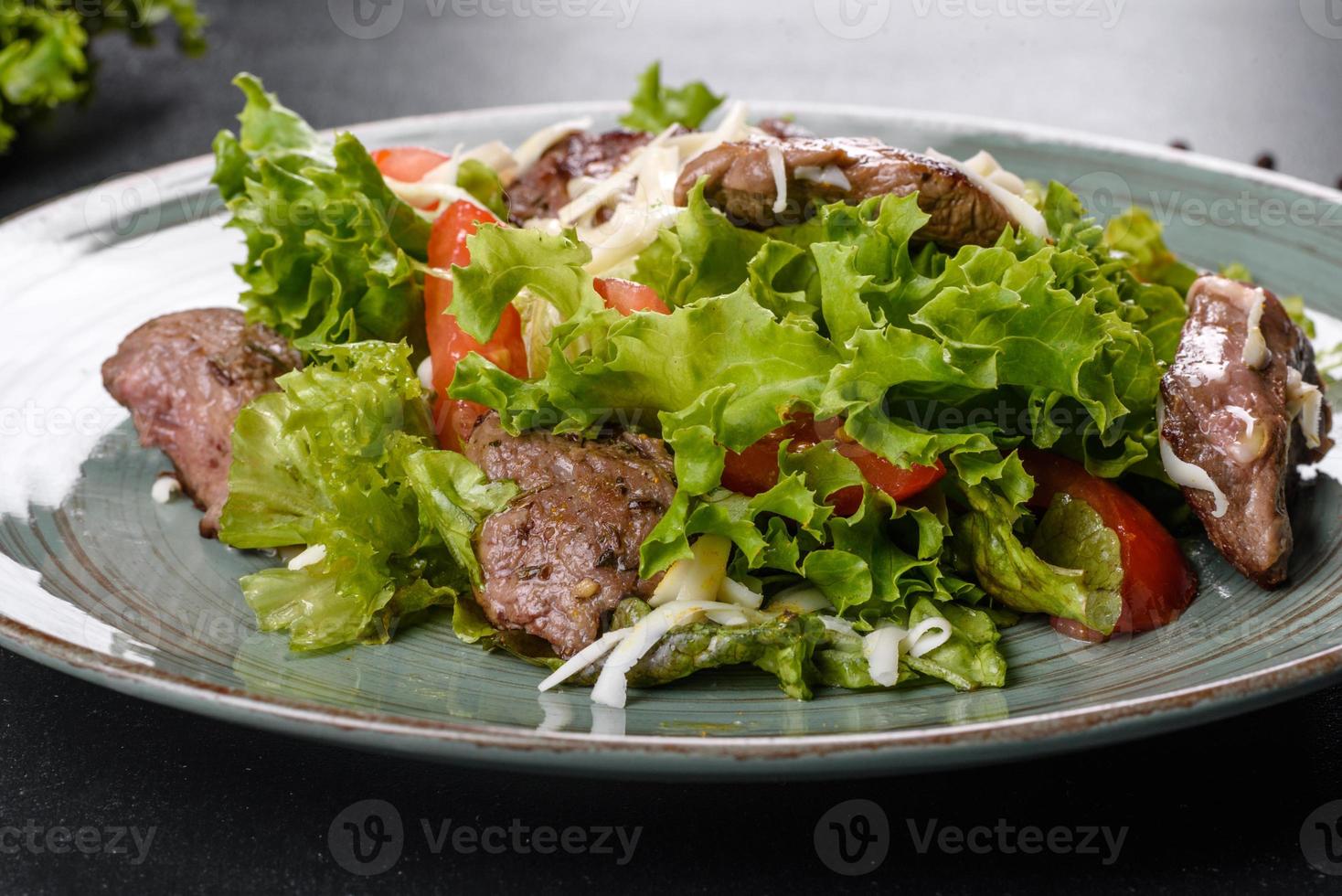 deliziosa insalata fresca con manzo, formaggio, pomodori e foglie di lattuga foto