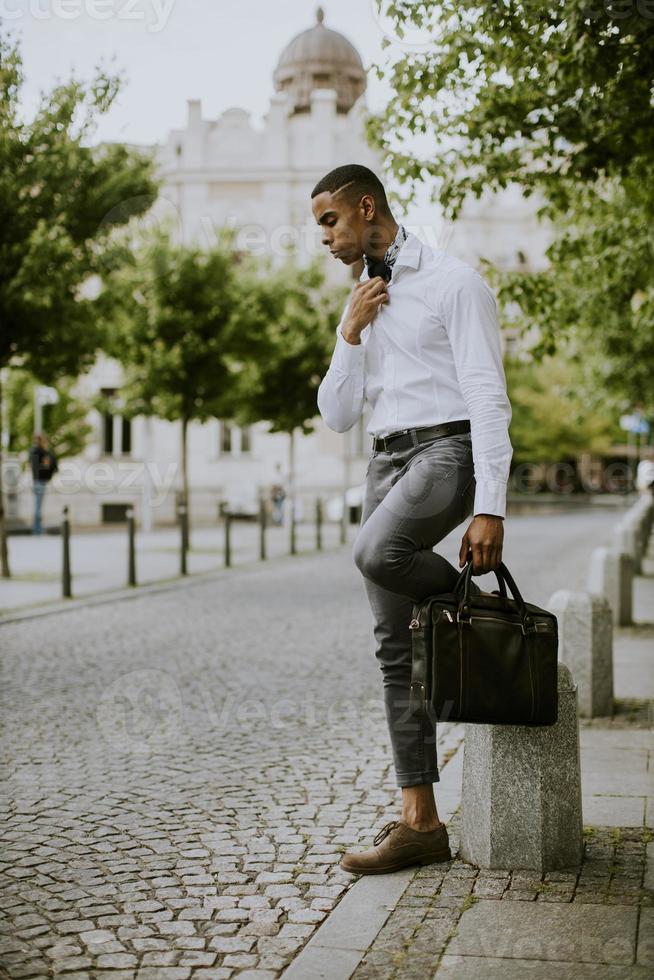 giovane uomo d'affari afroamericano waitng un taxi su una strada foto