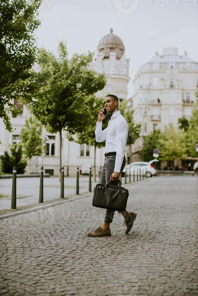 giovane uomo d'affari afroamericano che utilizza un telefono cellulare foto