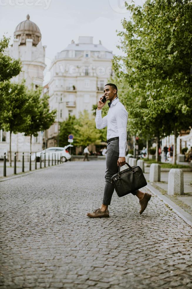 giovane uomo d'affari afroamericano che utilizza un telefono cellulare foto