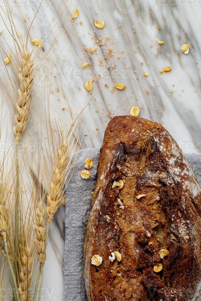 delizioso pane appena sfornato su sfondo marmo. stile di vita sano di dieta. foto