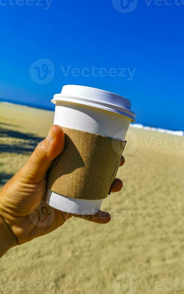 caffè per partire boccale su il spiaggia sabbia mare onde. foto