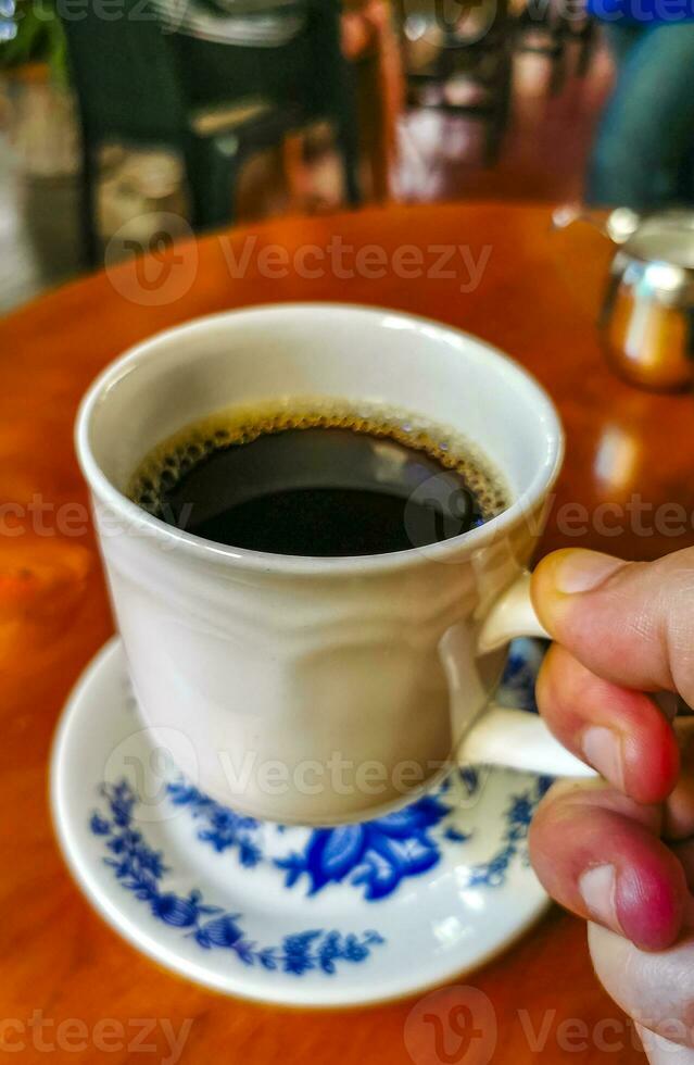 blu bianca tazza pentola con nero caffè di legno tavolo Messico. foto