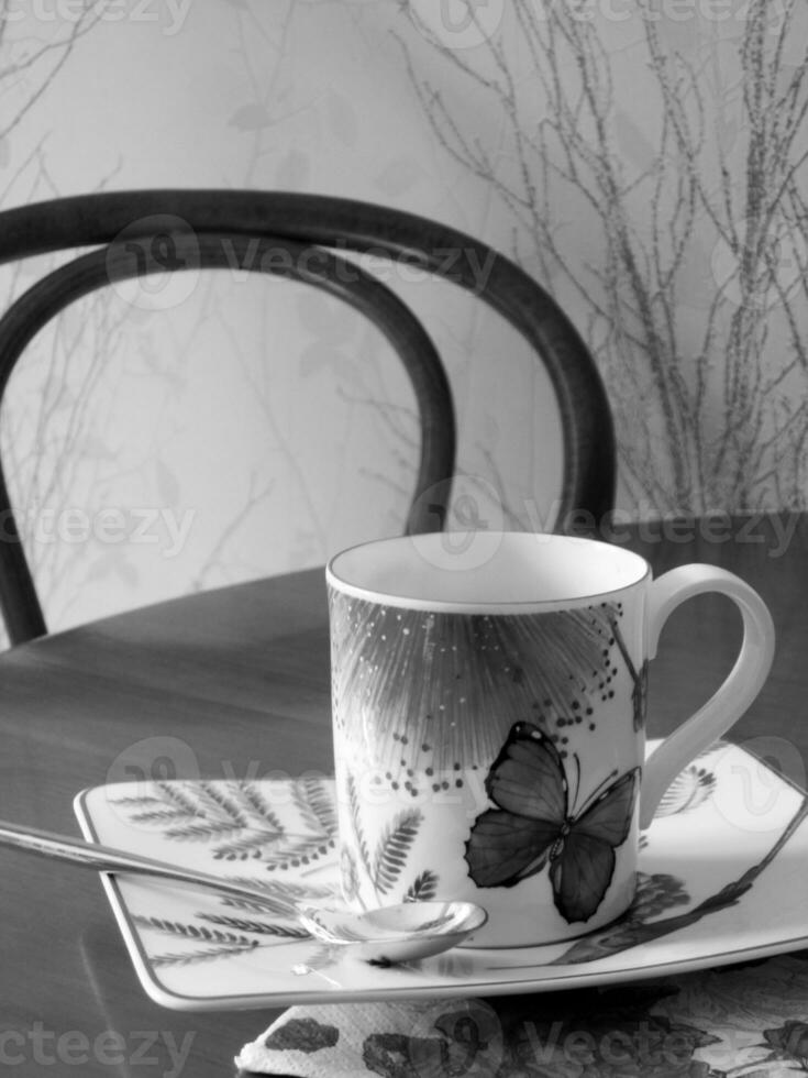 tazza da caffè di bellezza in piedi sul tavolo di legno con caffè scuro e gustoso foto