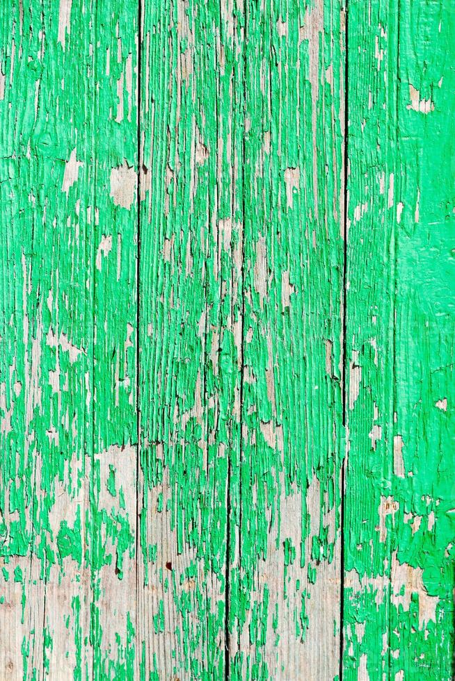 primo piano di una vecchia porta di legno, vernice verde che si staccava dallo sfondo della trama foto