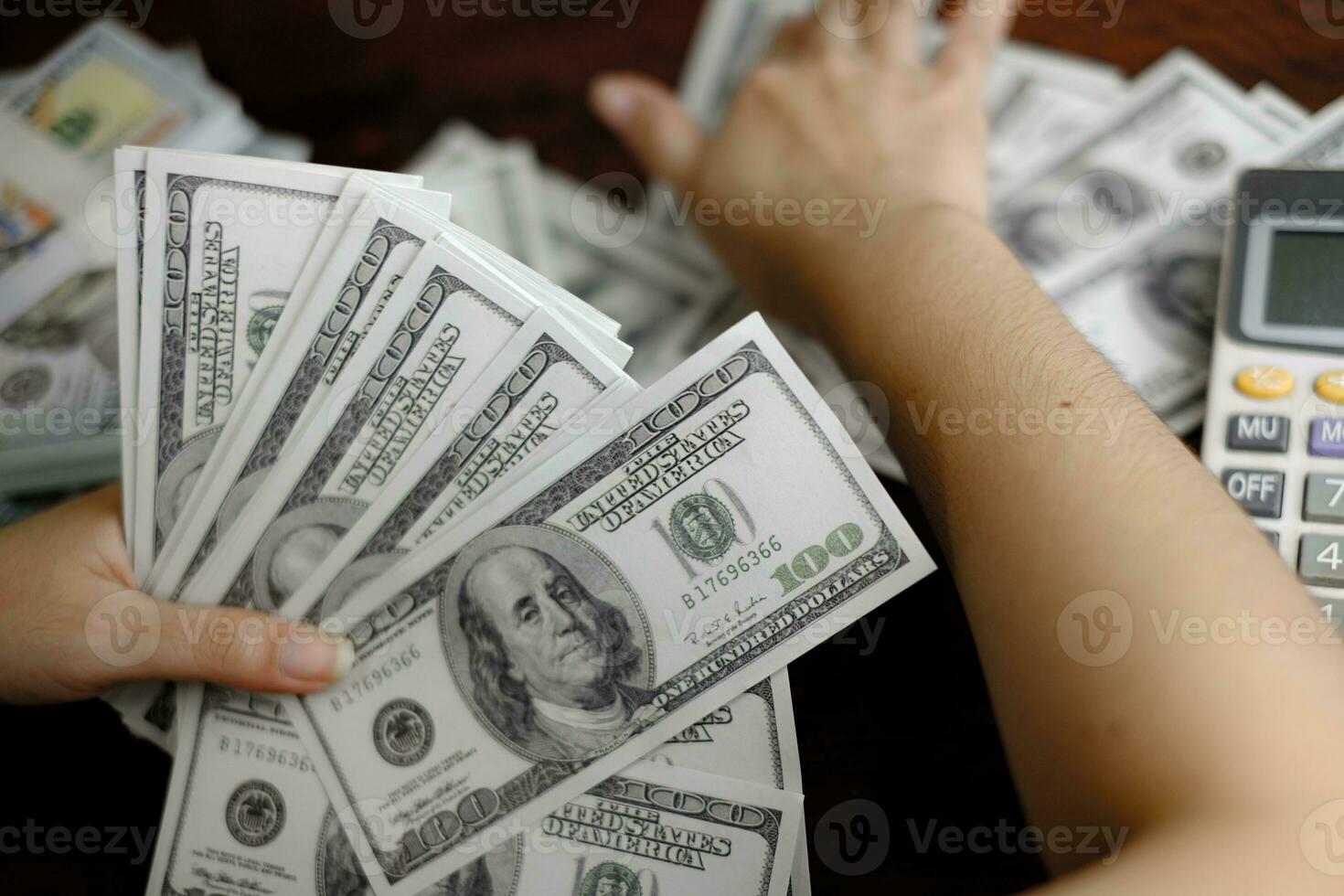 uomini d'affari donne che contano soldi su una pila di 100 dollari americani banconote un sacco di soldi foto