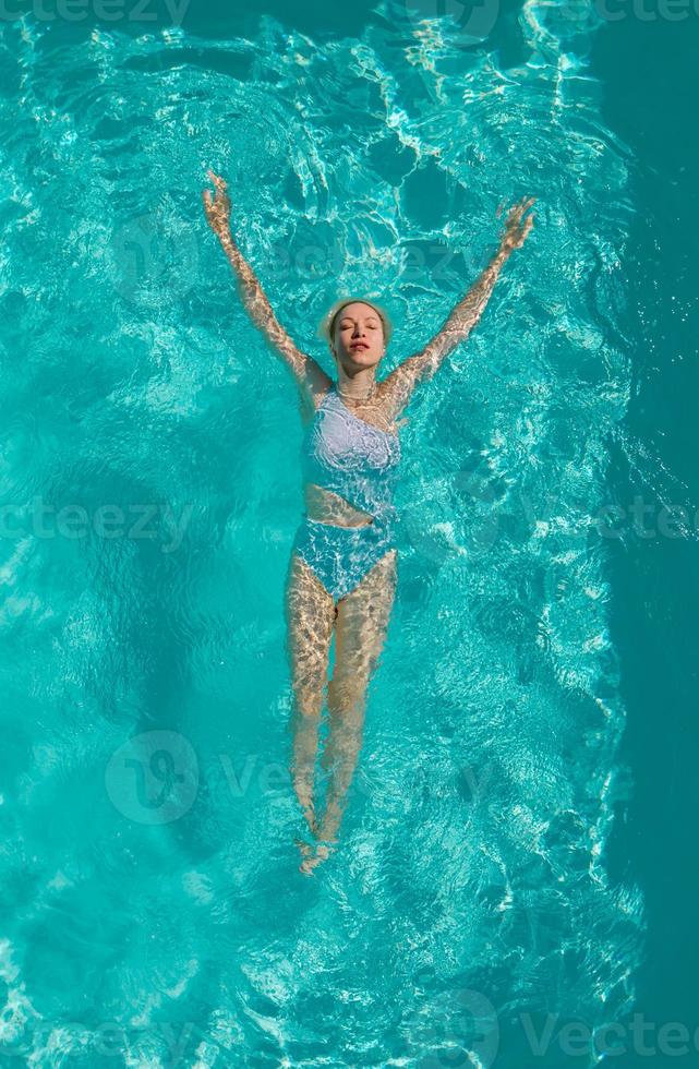 giovane bella ragazza sexy che si gode il nuoto nella piscina privata e si rilassa al sole foto
