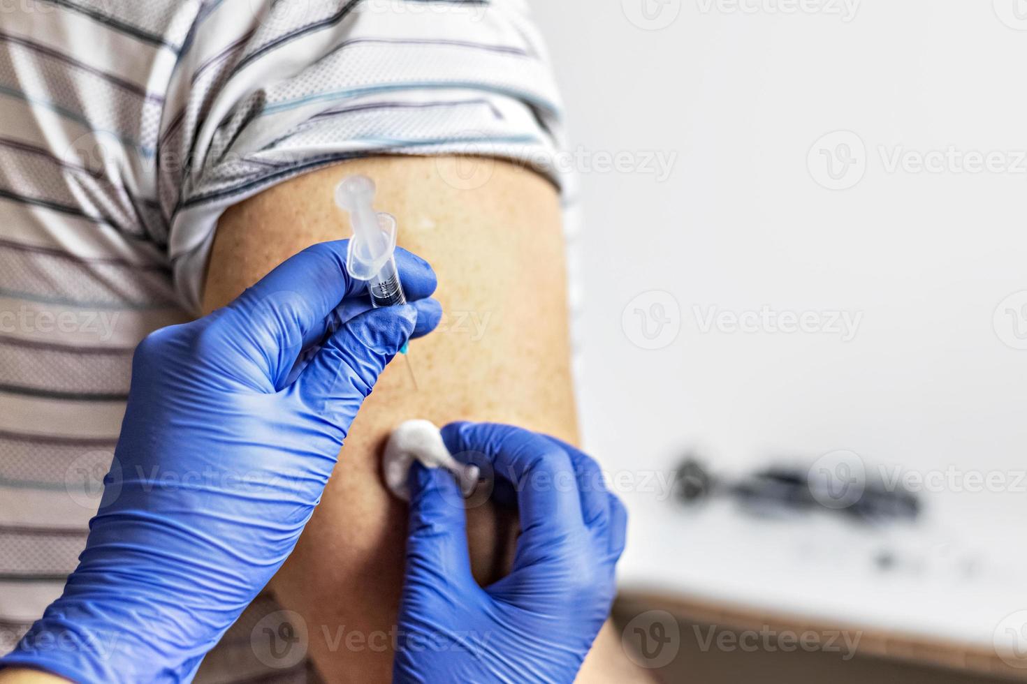 un medico vaccina un uomo contro il coronavirus in una clinica. avvicinamento. il concetto di vaccinazione, immunizzazione, prevenzione contro covid-19. foto