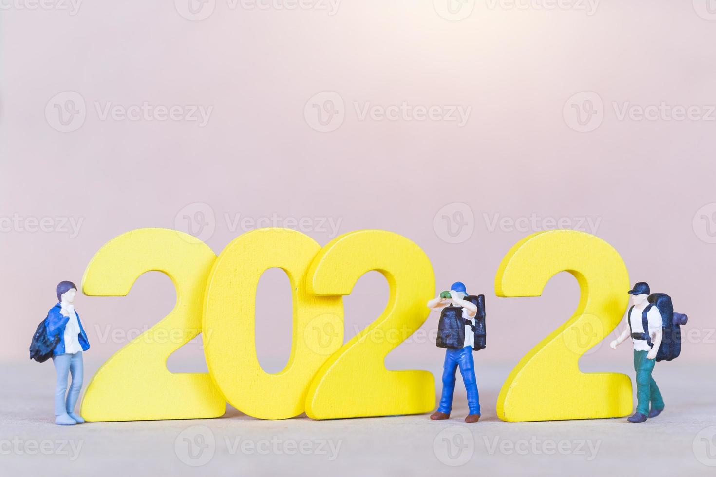 zaino in spalla di persone in miniatura in piedi sul numero di legno 2022 foto