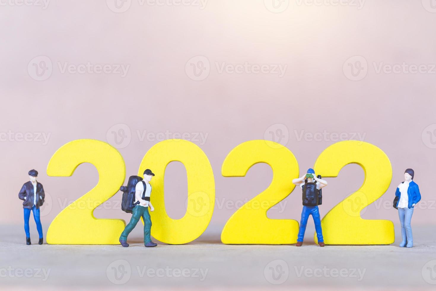 zaino in spalla di persone in miniatura in piedi sul numero di legno 2022 foto