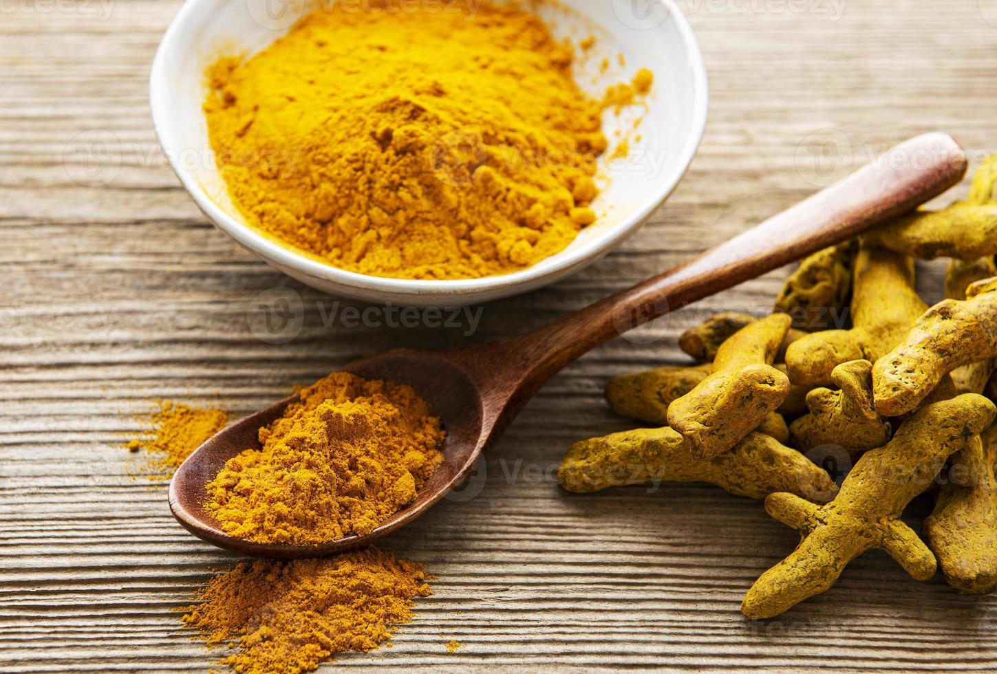 curcuma gialla in polvere e radici secche foto