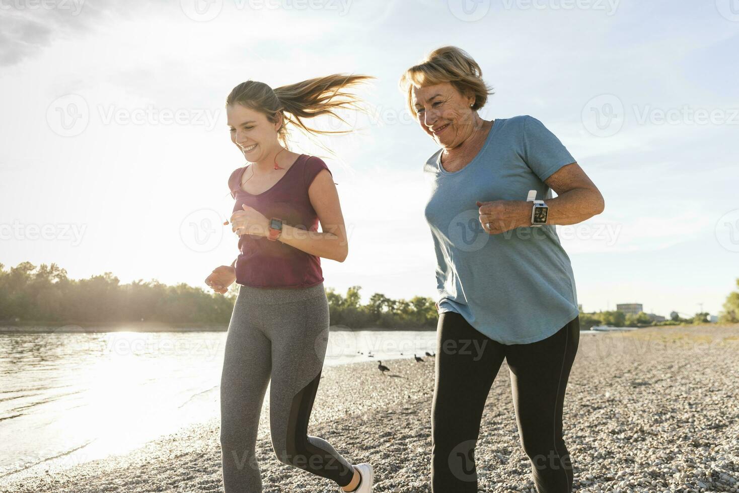 nipotina e nonna avendo divertimento, jogging insieme a il fiume foto