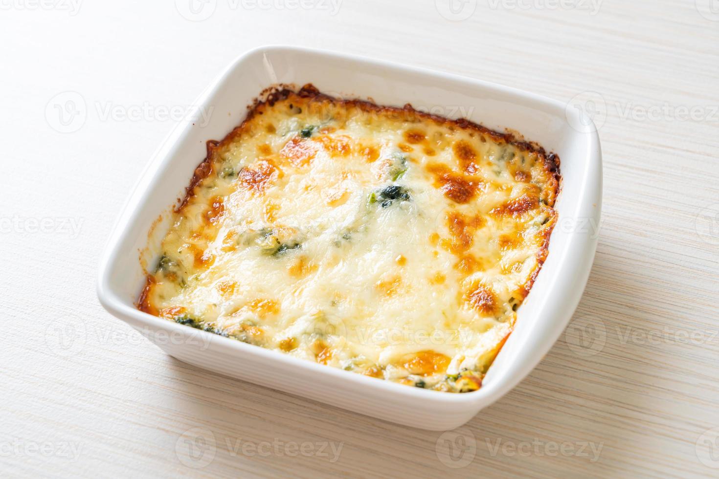 lasagne di spinaci al forno con formaggio in piatto bianco foto