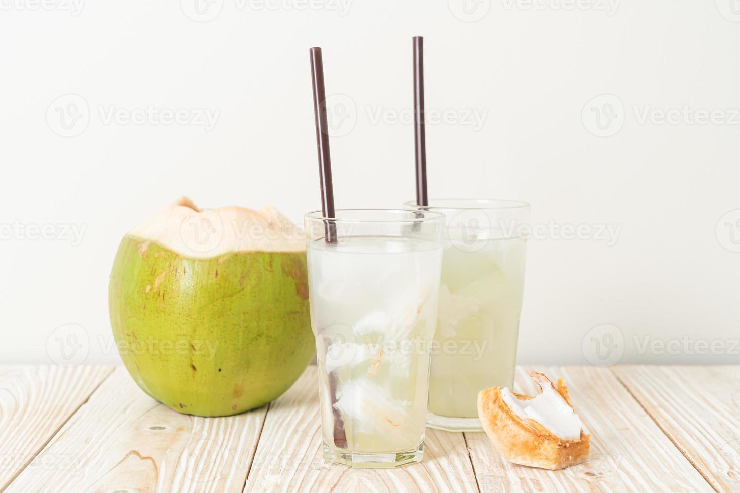 acqua di cocco o succo di cocco in bicchiere con cubetti di ghiaccio foto