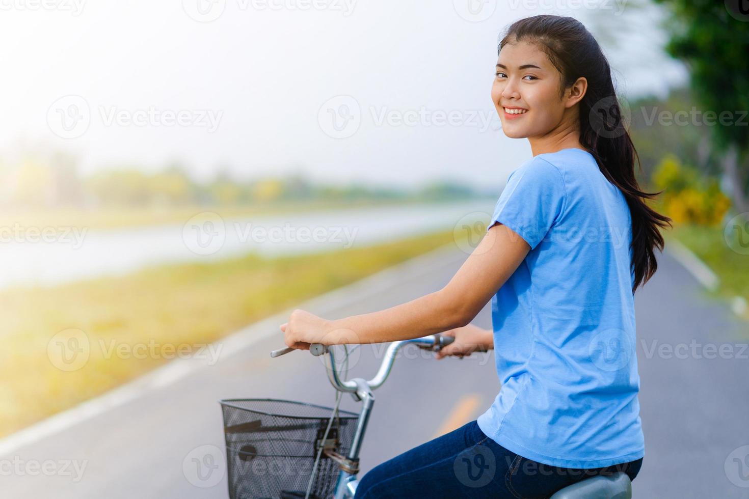 ragazza con la bici, donna che va in bicicletta su strada in un parco foto