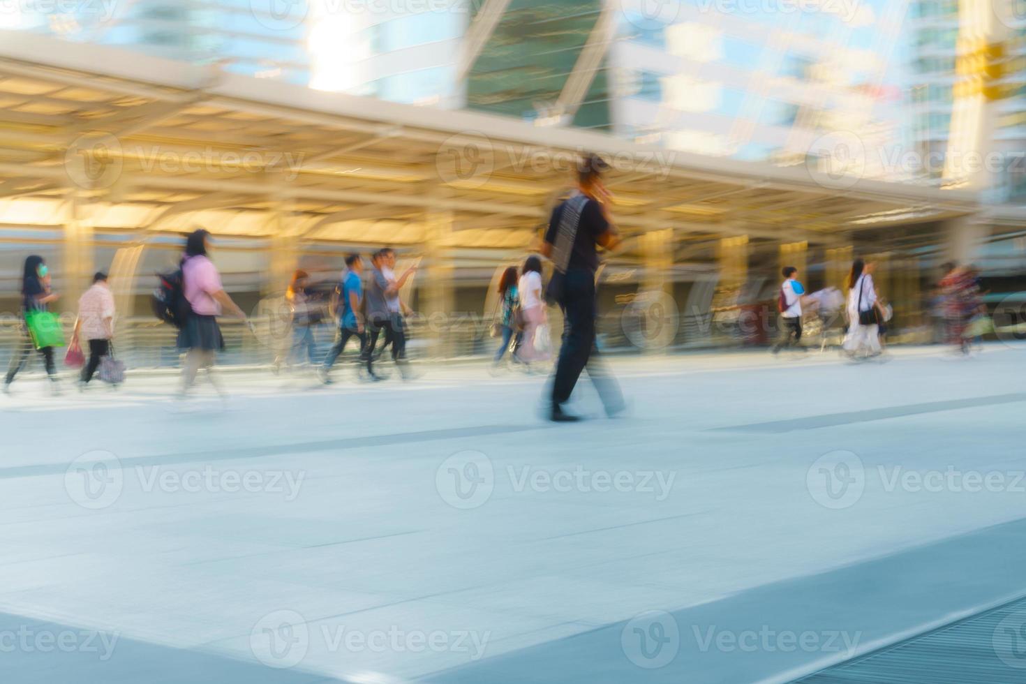 le persone che camminano in motion blur in città foto