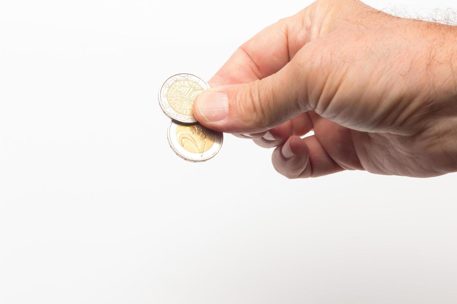 monete nella mano adulta su sfondo bianco foto