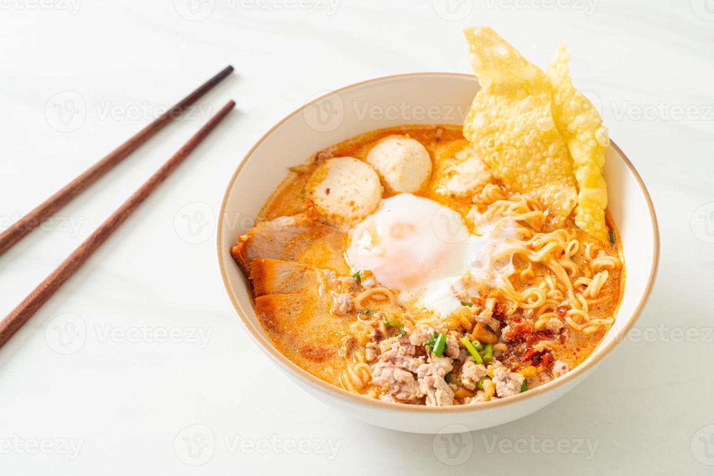 noodles istantanei con maiale e polpette in zuppa piccante o noodles tom yum in stile asiatico foto