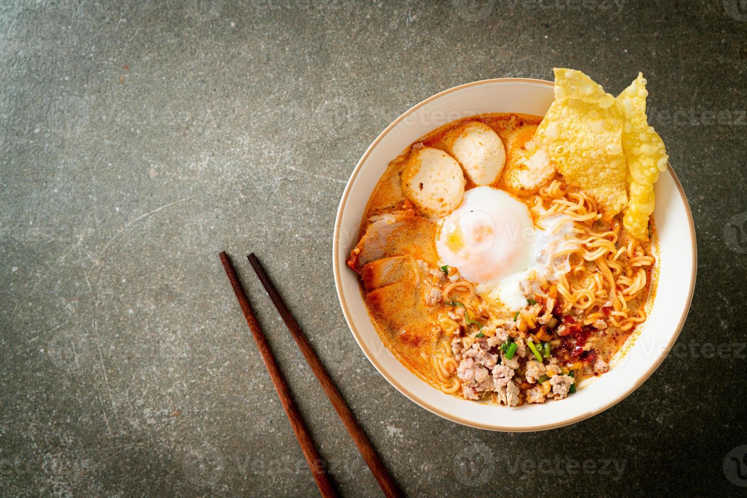 noodles istantanei con maiale e polpette in zuppa piccante o noodles tom yum in stile asiatico foto