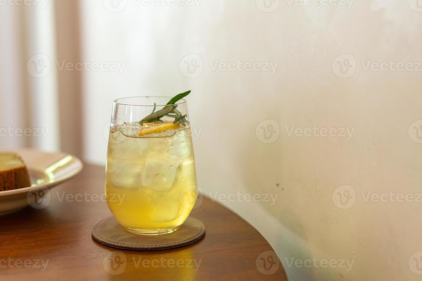 bicchiere di miele al limone ghiacciato con rosmarino nel ristorante caffetteria foto