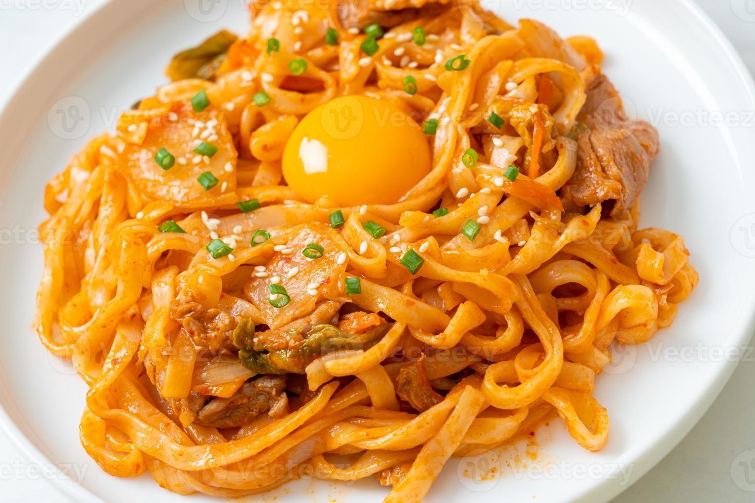 noodles udon saltati in padella con kimchi e maiale - stile alimentare coreano foto