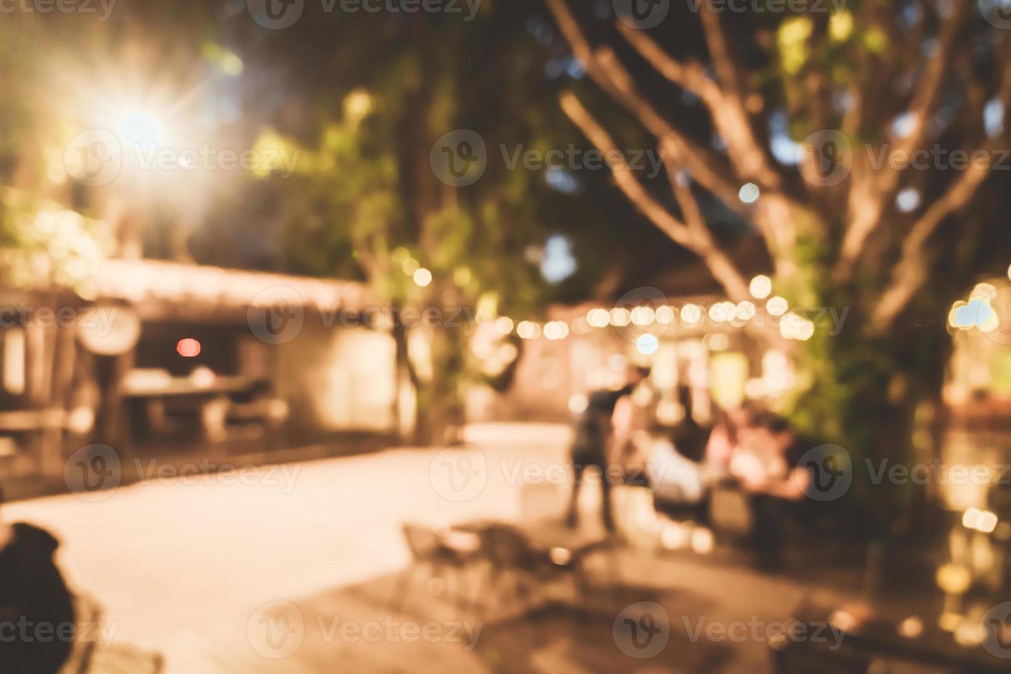 sfocatura astratta cortile di ritrovo all'aperto nel ristorante caffetteria di notte per lo sfondo foto