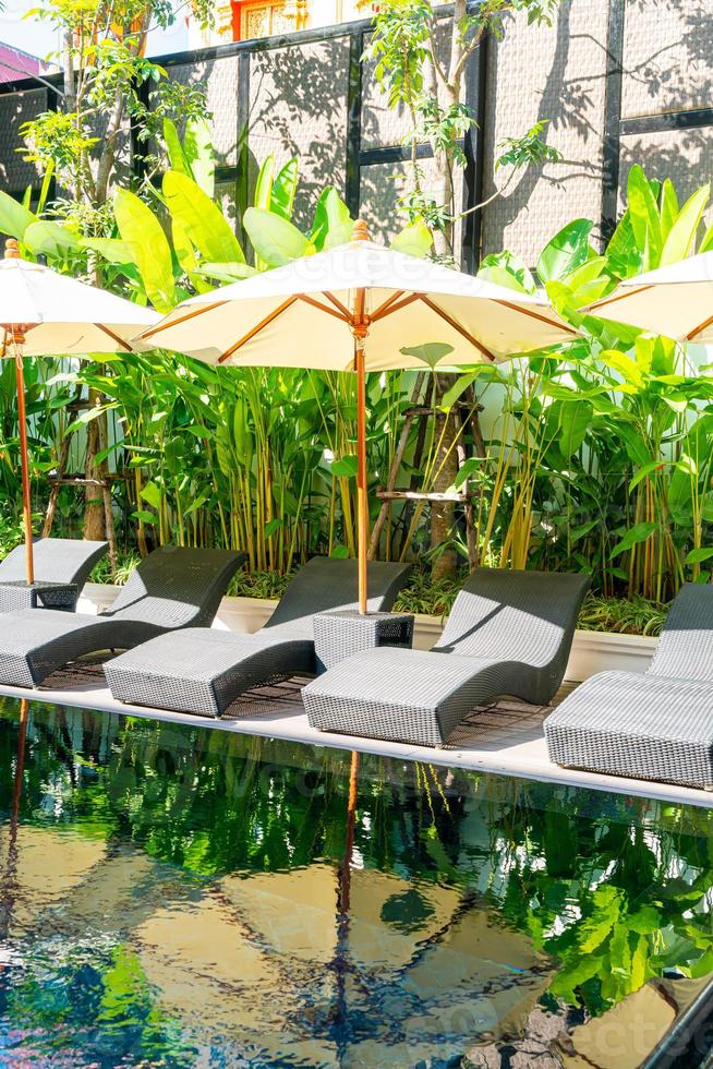ombrelloni e lettini da piscina intorno alla piscina - concetto di vacanza e viaggio foto