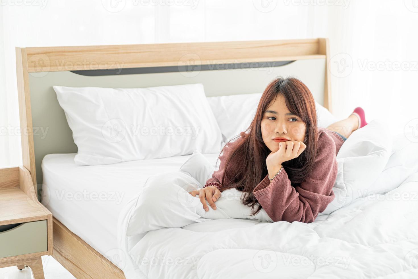 bella donna asiatica sdraiata sul letto la mattina foto