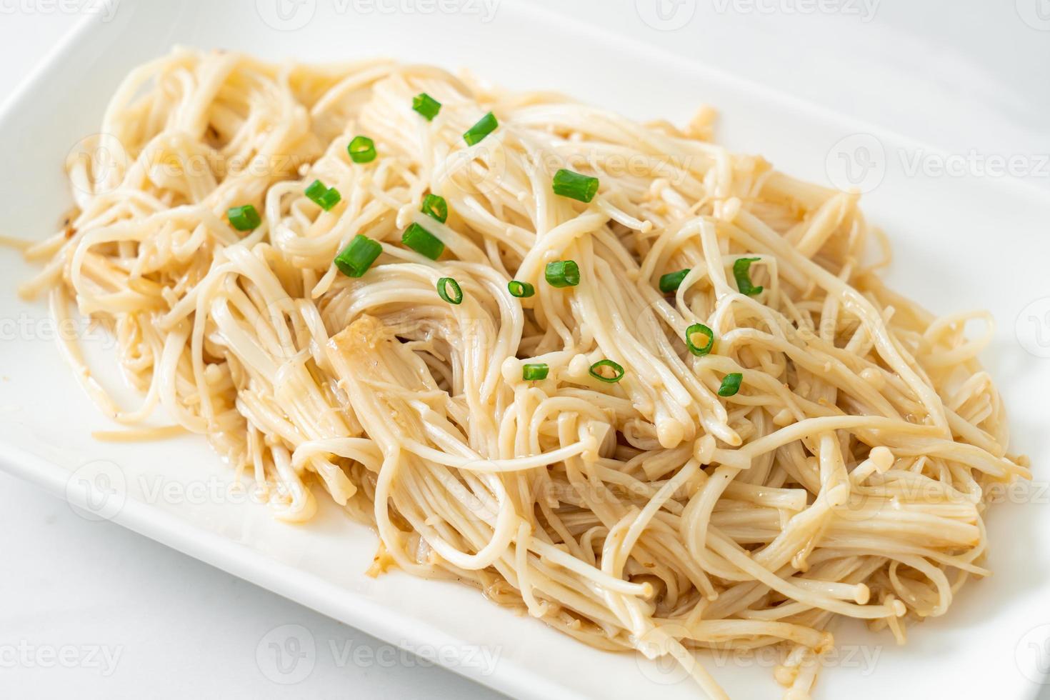 funghi aghi dorati saltati in padella con burro su piatto bianco foto