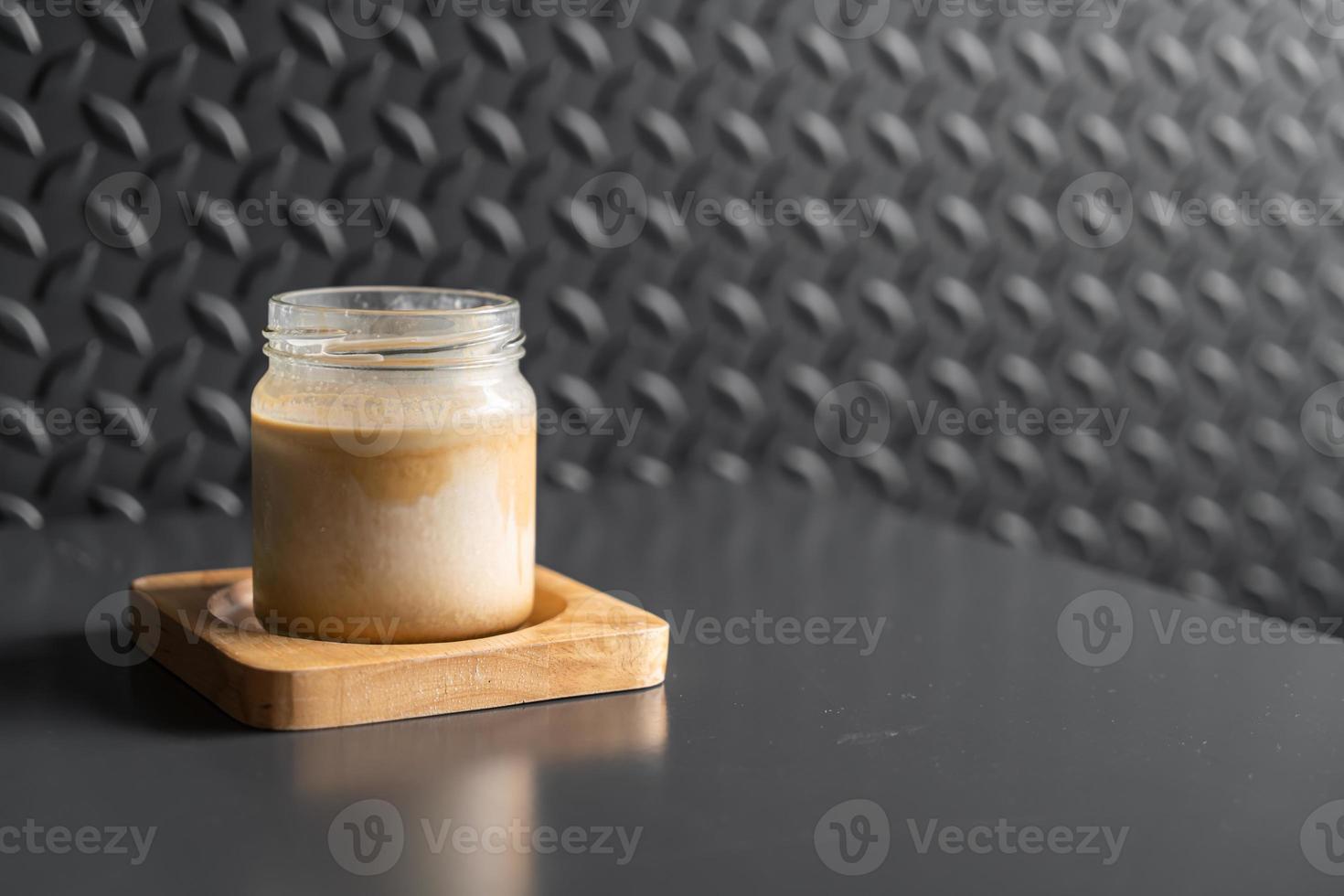 un bicchiere di caffè espresso sparato su latte fresco freddo crea uno strato sfumato chiamato caffè sporco dirty foto