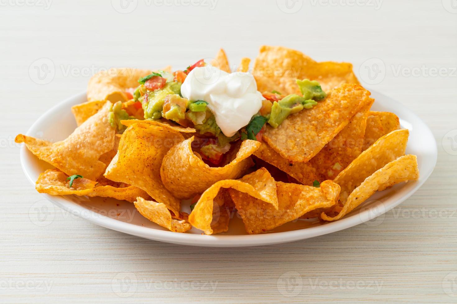 tortilla chips di nachos messicani con jalapeno, guacamole, salsa di pomodori e salsa foto