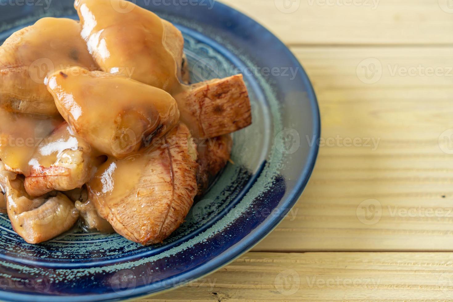 banane grigliate con salsa al caramello al cocco sul piatto foto