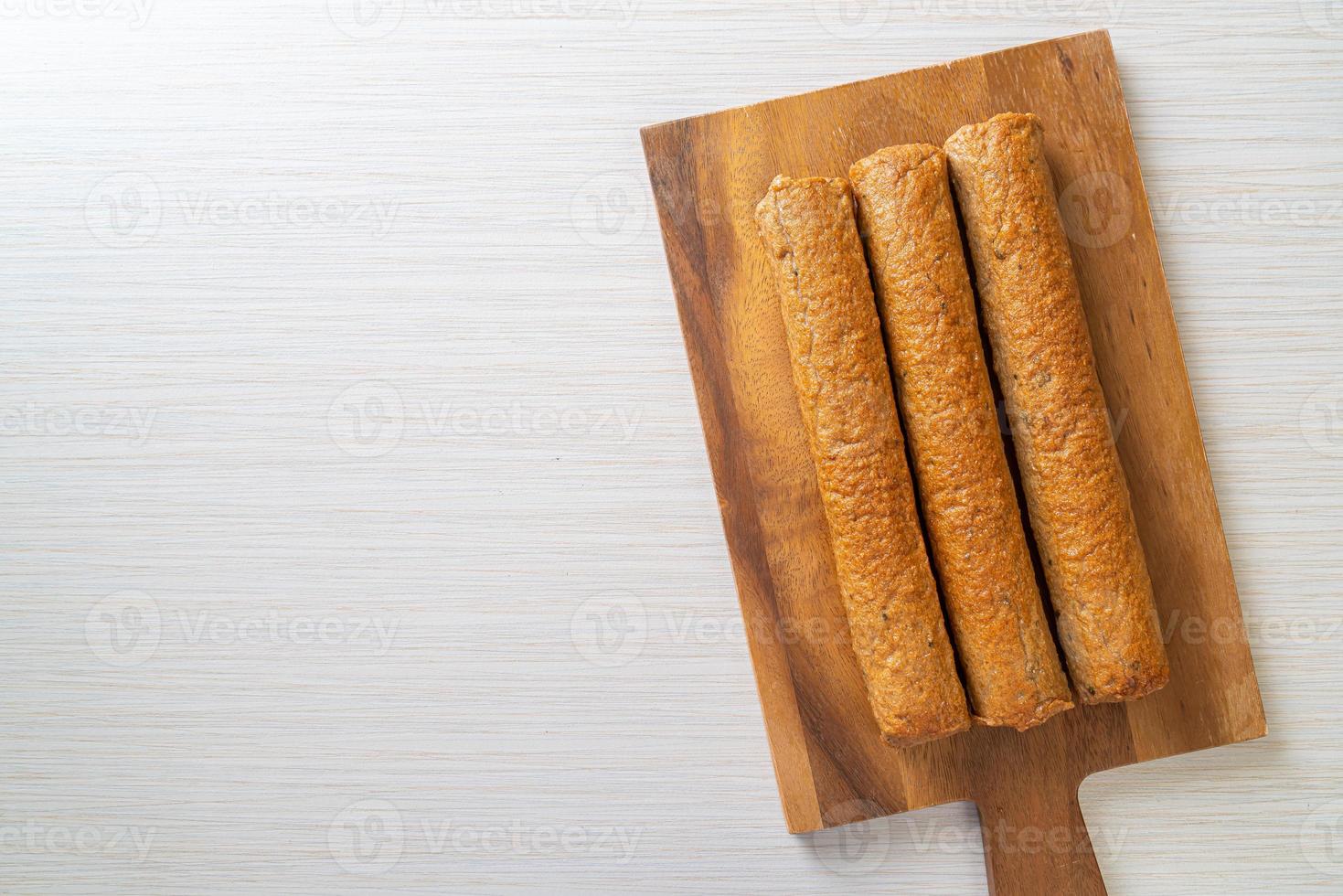 torta di pesce cinese fritta o linea di polpette di pesce su tavola di legno foto