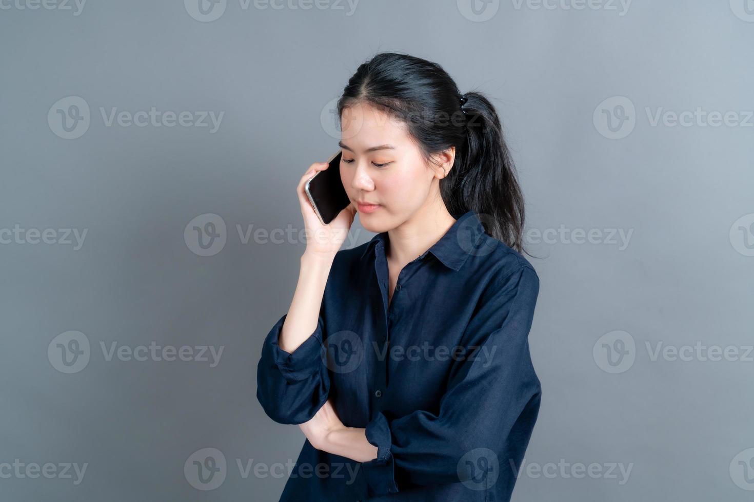 donna asiatica che utilizza il telefono cellulare parlando di affari foto