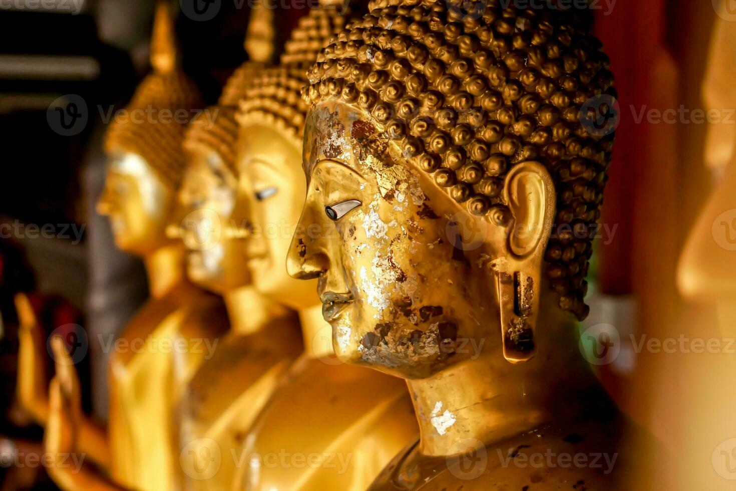 avvicinamento e Ritaglia vecchio e d'oro viso di d'oro Budda statua su sfocato d'oro Budda statua In piedi forte linea sfondo foto