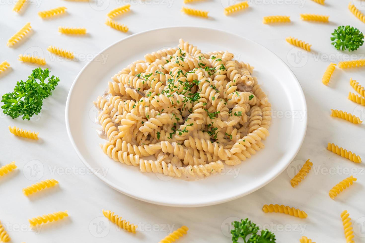 spirali o pasta a spirale salsa di crema di funghi con prezzemolo - stile alimentare italiano foto