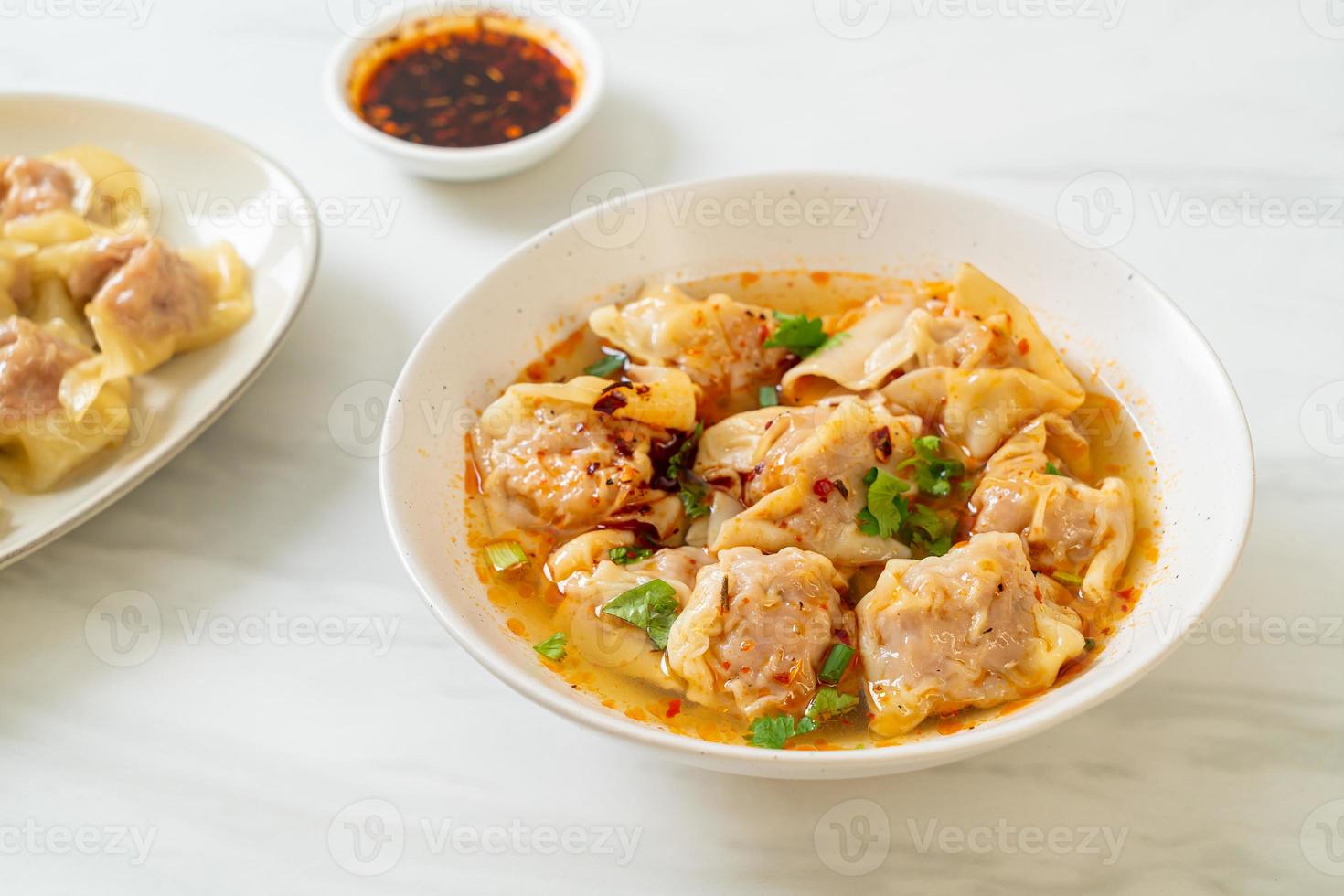 zuppa di wonton di maiale o zuppa di gnocchi di maiale con peperoncino arrosto - stile asiatico foto