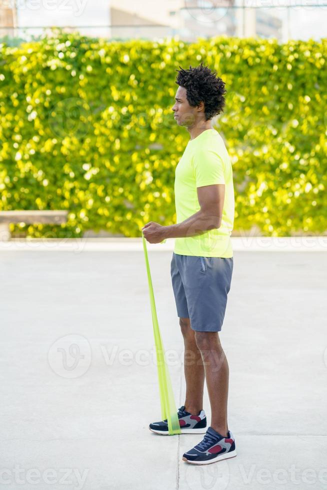 uomo di colore che si allena con l'elastico all'aperto foto