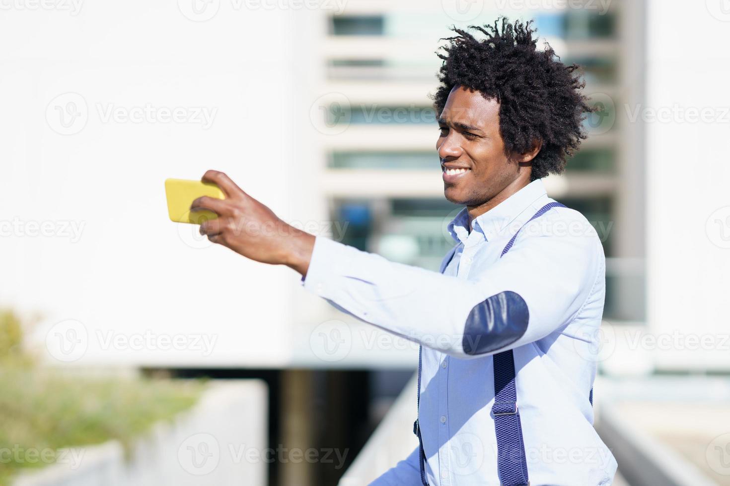 uomo d'affari nero che si fa un selfie con il suo smartphone foto