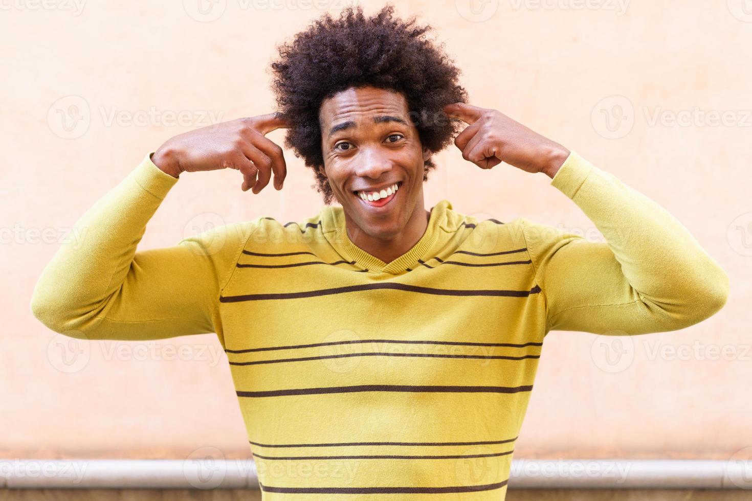 uomo di colore con i capelli afro che fa un'espressione pazza foto