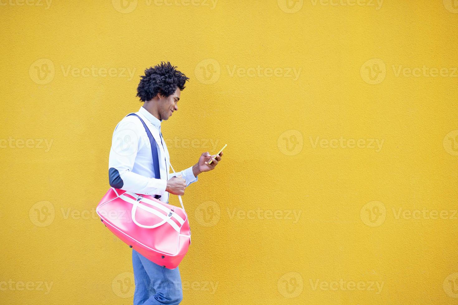 uomo di colore con acconciatura afro che porta una borsa sportiva foto