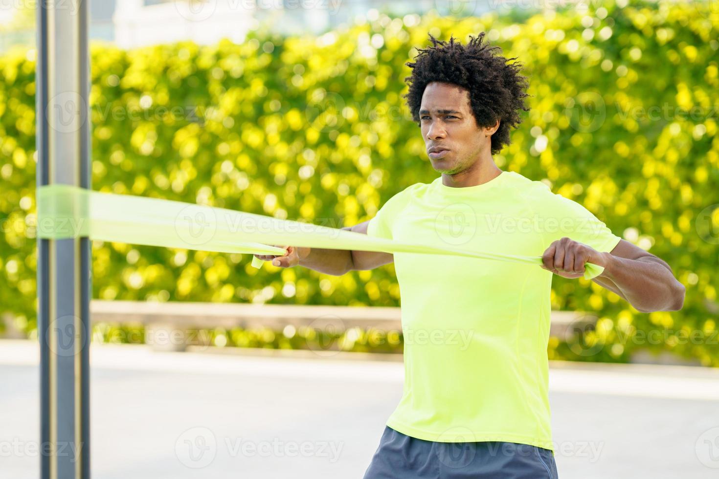 uomo di colore che si allena con l'elastico all'aperto foto