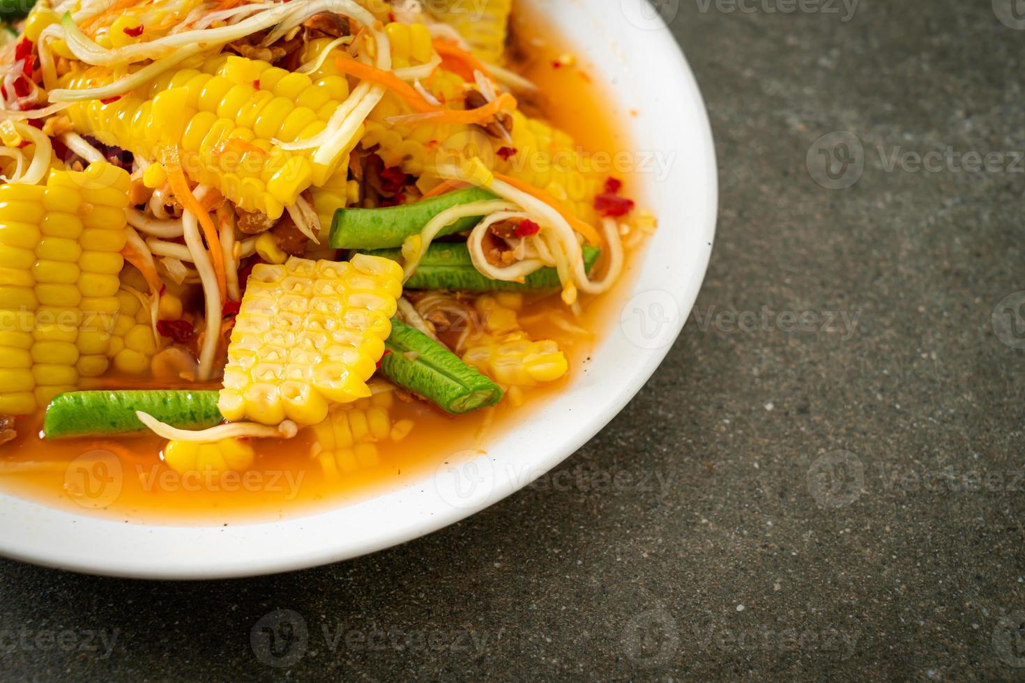 som tum - insalata di papaya piccante tailandese con mais foto